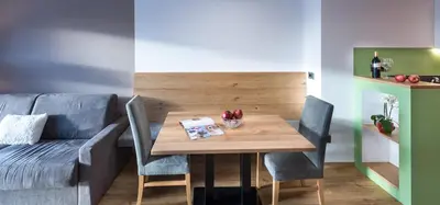 a dining room with a table and a couch at Putzerhof in Siusi