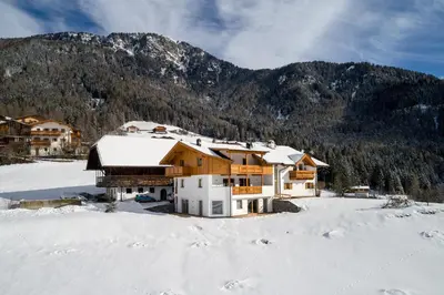a house in the snow in front of a mountain at Putzerhof in Siusi