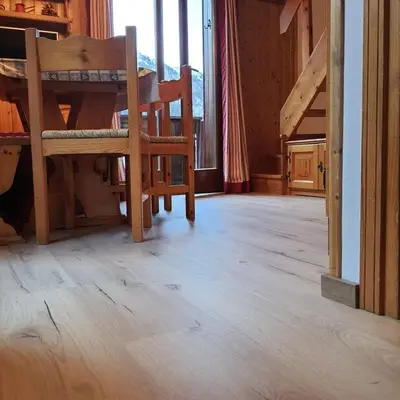 a room with wooden floors and chairs in a house at Casa Penia 2 in Canazei