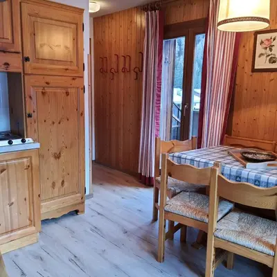 a dining room with a table and a kitchen at Casa Penia 2 in Canazei