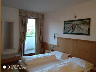 a hotel room with a bed and a window at Hotel Rosa Resort in Cavareno