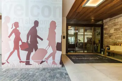 a mural of people walking in front of a building at Hotel Braunsbergerhof in Lana
