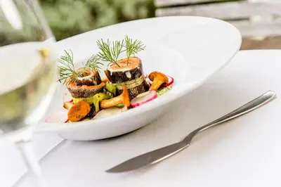 a white bowl of food on a table with a spoon at Hotel Braunsbergerhof in Lana