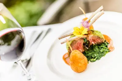 a plate of food and a glass of wine at Hotel Braunsbergerhof in Lana