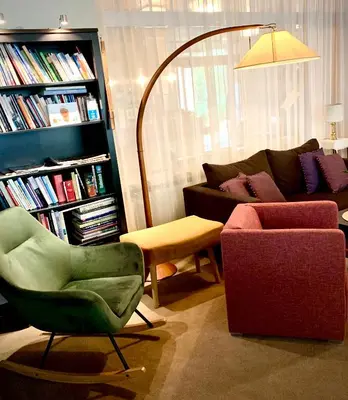 a living room with a couch and a chair at Hotel Braunsbergerhof in Lana