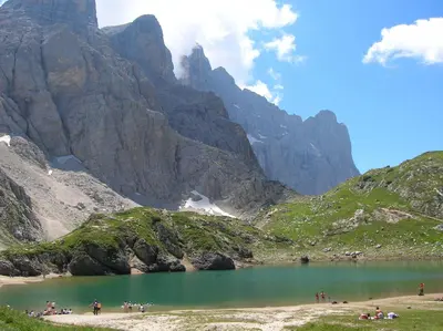 a group of people standing around a mountain lake at Hotel Corona in Val di Zoldo