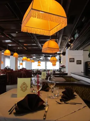 a table in a restaurant with a yellow chandelier at Hotel Corona in Val di Zoldo