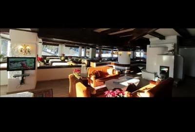 a large living room with couches and a television at Hotel Corona in Val di Zoldo