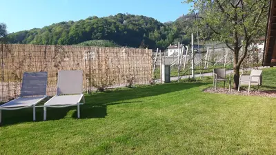 a yard with two chairs and a fence at Versigglhof in Appiano sulla Strada del Vino