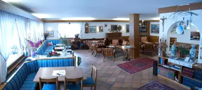 a hotel with a table and chairs in front of it at Liz Hotel & Apartments in Predazzo