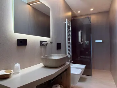 a bedroom with a large bed and a bench at Liz Hotel & Apartments in Predazzo