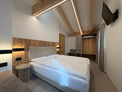 a bedroom with a bed in a room at Liz Hotel & Apartments in Predazzo