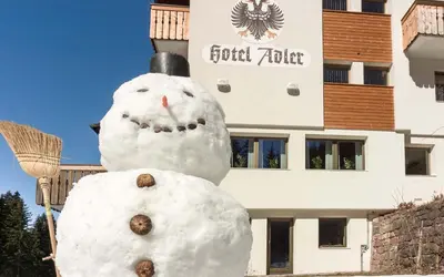 a snowman standing in front of a building at Hotel ADLER Carezza in Nova Levante
