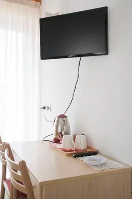 a table with a television on top of it at Garnì Mariolina in Falcade