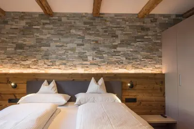 two beds in a room with a brick wall at Appartment Hossler in Valdaora