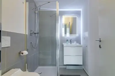 a bathroom with a shower and a toilet and a sink at Sonnenuhr Bolzano Apartments in Bolzano