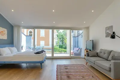 a living room with a bed and a couch at Sonnenuhr Bolzano Apartments in Bolzano