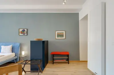 a living room with a bed and a table at Sonnenuhr Bolzano Apartments in Bolzano