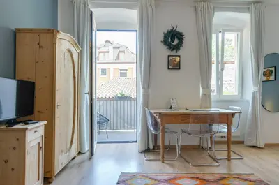 a living room with a desk and a television at Sonnenuhr Bolzano Apartments in Bolzano