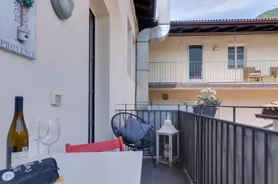 a balcony with a table and chairs and a bottle of wine at Sonnenuhr Bolzano Apartments in Bolzano