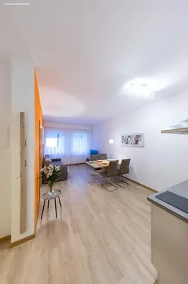 an empty living room with a table and chairs at City Charme Apartments in Bolzano