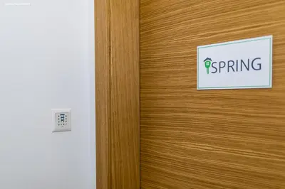 a sign on a wooden door with the word spring on it at City Charme Apartments in Bolzano