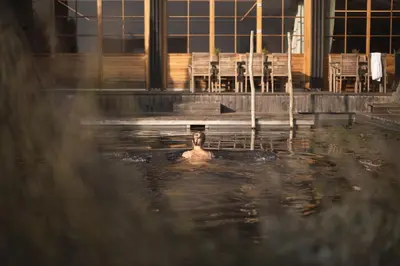 a man swimming in a pool of water at Kräutererbe Bacherhof in Nalles