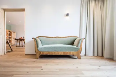a living room with a couch and a mirror at Kräutererbe Bacherhof in Nalles