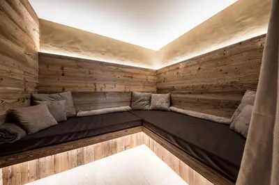 a room with a bed in a wooden wall at Kräutererbe Bacherhof in Nalles