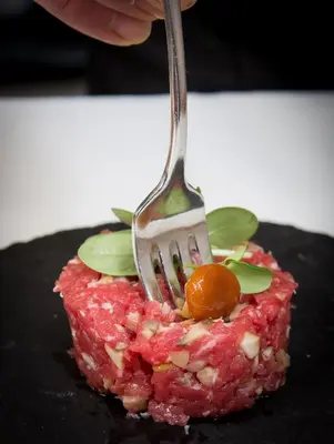 a fork picking up a piece of food on a plate at Historic Hotel Ristorante La Stua in Cavalese