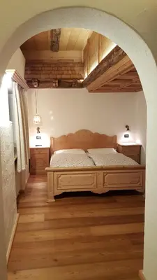 a bedroom with a bed in a room with an archway at Historic Hotel Ristorante La Stua in Cavalese