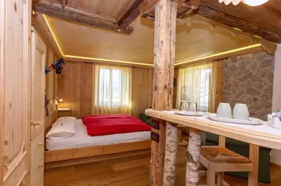 a small room with a bed and a table at Historic Hotel Ristorante La Stua in Cavalese