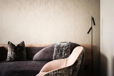 a living room with a couch with pillows at Hotel Belaval in Selva di Val Gardena