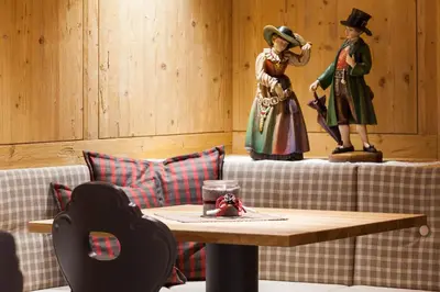 a coffee table with two figurines on top of a couch at Hotel Belaval in Selva di Val Gardena