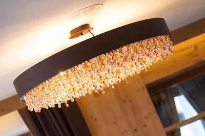 a chandelier is hanging from a ceiling at Hotel Belaval in Selva di Val Gardena