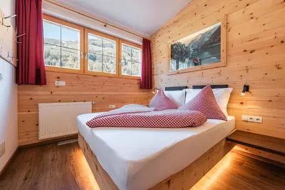 a bedroom with a bed with red and white pillows at Hotel Appartement Haus Gitschberg in Vandoies