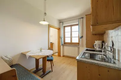a small kitchen with a sink and a table at Hofer am Bach in Lagundo