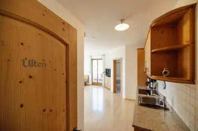a kitchen with wooden cabinets and a hallway at Hofer am Bach in Lagundo