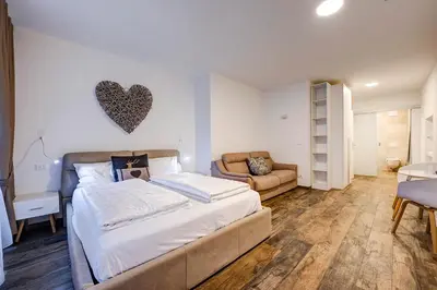a bedroom with a large bed and a couch at Taste Living in Merano