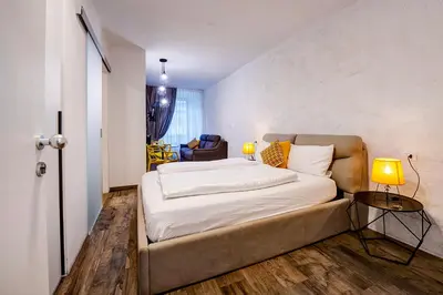 a bedroom with a bed and a living room at Taste Living in Merano