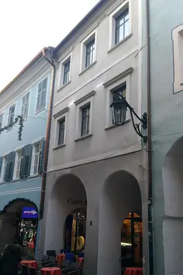 a large white building with arches and tables and chairs at Taste Living in Merano