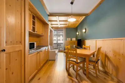a kitchen and dining room with a table and chairs at Radisson Residences Savoia Palace Cortina d’Ampezzo in Cortina dʼAmpezzo
