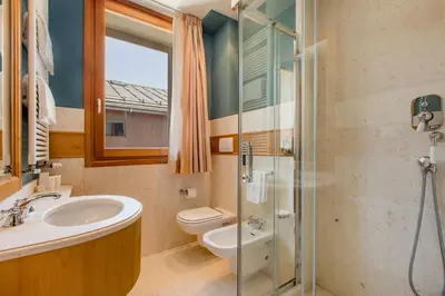a bathroom with a sink and a toilet and a shower at Radisson Residences Savoia Palace Cortina d’Ampezzo in Cortina dʼAmpezzo
