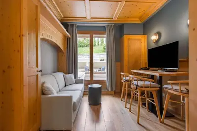 a living room with a white couch and a table at Radisson Residences Savoia Palace Cortina d’Ampezzo in Cortina dʼAmpezzo