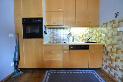 a kitchen with wooden cabinets and a black microwave at Apartment Nogler Frieda in Selva di Val Gardena