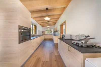 a kitchen with wooden cabinets and a counter top at Chalet Dumbria Dolomites in Selva di Val Gardena