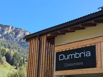 a sign on the side of a building with a mountain at Chalet Dumbria Dolomites in Selva di Val Gardena