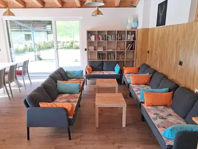 a living room with couches and a book shelf at Chalet Dumbria Dolomites in Selva di Val Gardena