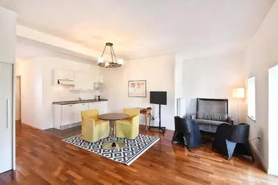 a living room with a table and chairs and a couch at Villa Verdi Apartments in Merano