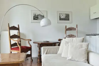 a living room with a couch and a table and chairs at Villa Verdi Apartments in Merano
